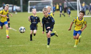 A Sion Swifts under-9's player in a race for the ball.