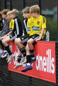 These youngsters watch the action from the sidelines at the Bishop's Field.